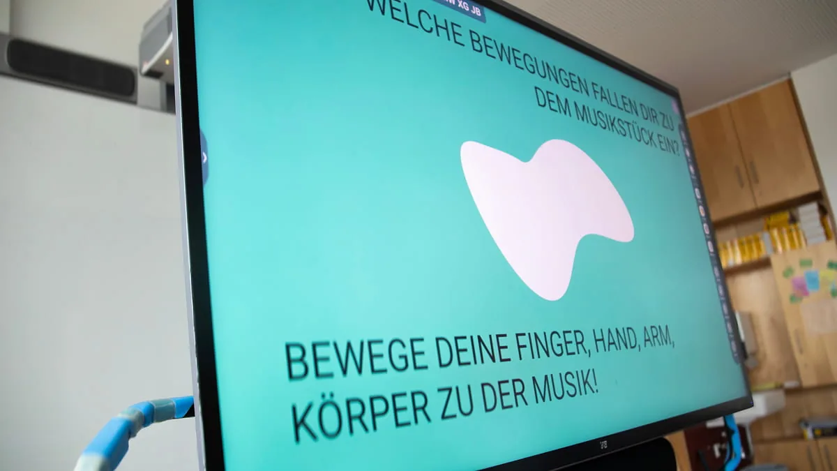 Bildschirm mit türkisfarbener Workshop-Folie und der Frage „Welche Bewegungen fallen dir zu dem Musikstück ein?